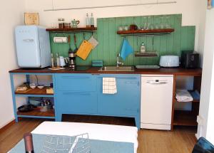 a kitchen with blue cabinets and a sink at Seeblick VILLA LAGUNA BLUE - Private Spa - Whirlpool & Sauna in Gardone Riviera