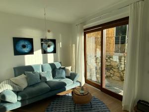a living room with a blue couch and a window at Seeblick VILLA LAGUNA BLUE - Private Spa - Whirlpool & Sauna in Gardone Riviera
