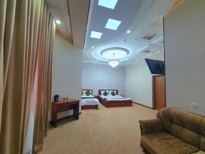 a room with two beds and a couch and a ceiling at DREAM PLAZA HOTEL for your convenience in Bukhara