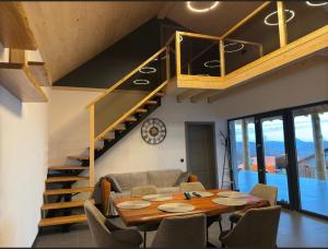 a living room with a table and a staircase at LuMar Lodge Tohăniță Zarnesti in Zărneşti