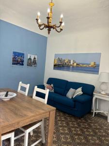 a living room with a blue couch and a table at Annacare in Trapani +8 photos