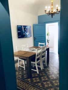 a dining room with a wooden table and white chairs at Annacare in Trapani