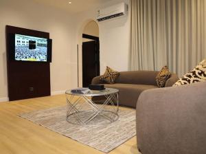 a living room with a couch and a table at قصر الرحابة للشقق المخدومة in Hawāyā