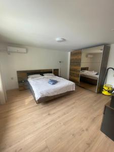 a bedroom with a bed and a large mirror at Апартамент ФЕРДИНАНД in Ruse