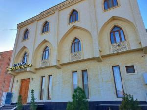 a large brick building with a sign on it at DREAM PLAZA HOTEL for your convenience in Bukhara