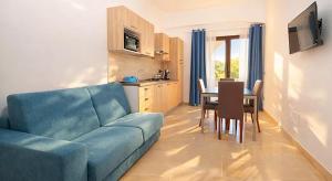 a living room with a blue couch and a table at Kalispera Residence in Scalea