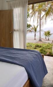 a bedroom with a bed with a view of the beach at Playa Mulata in Moñitos