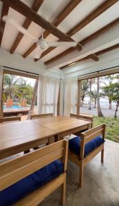 a dining room with a wooden table and two chairs at Playa Mulata in Moñitos