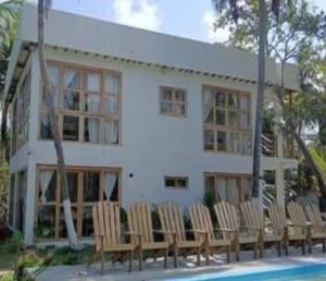 a building with chairs in front of a pool at Playa Mulata in Moñitos