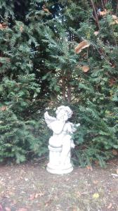 a white angel statue in front of a christmas tree at La Carline in Guillestre