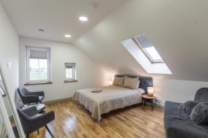 a bedroom with a bed and a couch and a skylight at Villa Asta in Rusnė