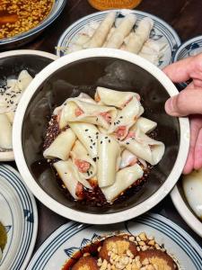 a bowl of food on a table with plates of food at 恩宜客栈 in Dujiangyan