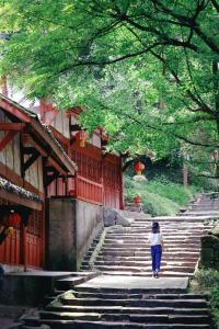 a woman walking up the stairs of a building at 恩宜客栈 in Dujiangyan