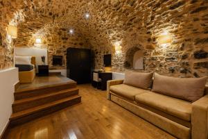 a living room with a couch in a stone wall at Voltes Mesta in Mestá