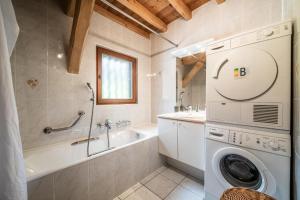 a bathroom with a washing machine and a bath tub at La Ferme de Sous-Lachat in Samoëns +134 photos