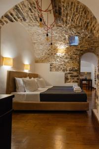 a bedroom with a bed and a stone wall at Voltes Mesta in Mestá
