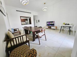 a living room with a table and chairs and a tv at Golden Homes 2 in Dubai