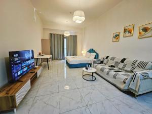 a living room with a couch and a flat screen tv at Golden Homes 2 in Dubai