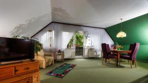 a living room with a tv and a table with chairs at Ferienwohnungen Anders in Braunlage