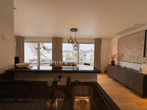 a living room with a sink and a large window at Maison Elouise in Middelkerke