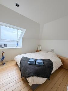 a bedroom with a bed with a black blanket and a window at Maison Elouise in Middelkerke +18 photos