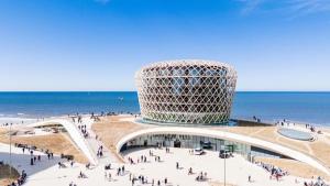 a building on the beach with a crowd of people at Maison Elouise in Middelkerke