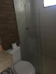 a bathroom with a toilet and a glass shower at casa cachoeira in Brasília