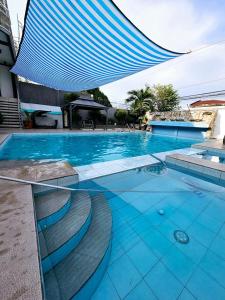 a large blue swimming pool with a blue umbrella at Crestscente Skye Villa Resort in Pañgil