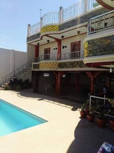 a large building with a swimming pool and a balcony at Crestscente Skye Villa Resort in Pañgil