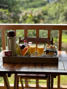a tray of food and drinks on a wooden table at Chalés Lavras de Minas - Brasil in Lavras Novas +23 photos