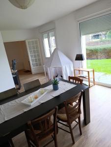 a dining room with a table and chairs and a room with a window at Maison bretonne 119 m2 - jardin clos - 30 min Côte Émeraude in Plénée-Jugon
