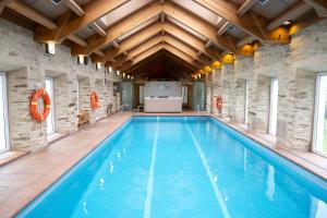 a large indoor swimming pool with a wooden ceiling at San Francisco Hotel Monumento in Santiago de Compostela