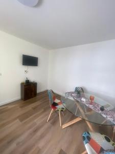 a living room with a glass table and chairs at Апартамент ФЕРДИНАНД in Ruse