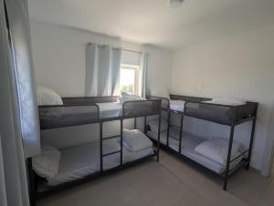 a room with three bunk beds and a window at הבית הכחול in Haspin +3 photos