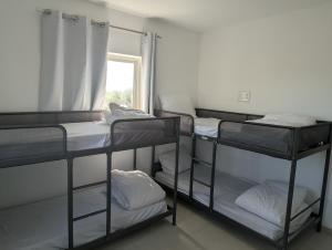 a room with three bunk beds and a window at הבית הכחול in Haspin