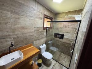 a bathroom with a toilet and a sink and a shower at refugio in Aguas Mornas
