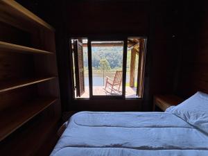 a bedroom with a bed and a window with a view at refugio in Aguas Mornas