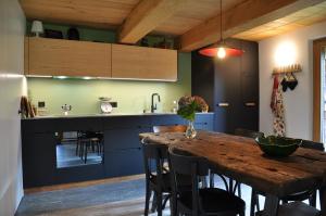 a kitchen with a wooden table and some chairs at Rustico La Stalla a Pianezza in Menzonio +25 photos