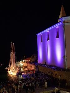 a group of people standing outside of a building at night at B&B Ciao Bella in Veli Lošinj