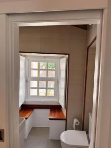 a small bathroom with a window and a toilet at Casa Da Muralha in Óbidos +71 photos