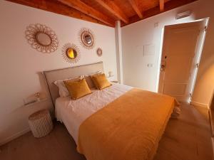 a bedroom with a bed with two mirrors on the wall at Casa Da Muralha in Óbidos