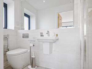 a white bathroom with a toilet and a sink at Knighton in Warmwell +55 photos