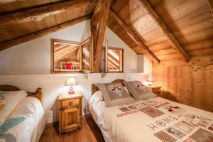 a bedroom with two beds in a room with wooden ceilings at La Ferme de Sous-Lachat in Samoëns