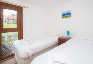 two beds in a room with a window at Chalet Seventyfour in Deal