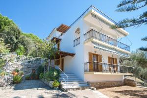 a white house with stairs and a balcony at Angela studios in Troulos