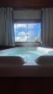 a large swimming pool in a room with a window at Chalés Lavras de Minas - Canadá in Lavras Novas