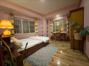 a bedroom with a bed and a lamp and a desk at Qeva Apartment I in Kathmandu