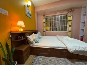 a small bedroom with a bed and a window at Qeva Apartment I in Kathmandu