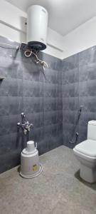 a bathroom with a toilet and a light on the wall at Elevate 1478 Inn in Nandigunda