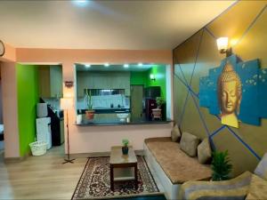 a living room with a couch and a painting of a head at Qeva Apartment I in Kathmandu